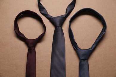 Different neckties on beige background, top view