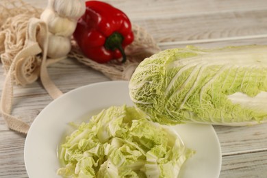 Photo of Fresh Chinese cabbage, bell pepper and garlic on wooden table, closeup