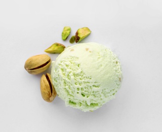 Photo of Scoop of delicious pistachio ice cream and nuts on white background, top view