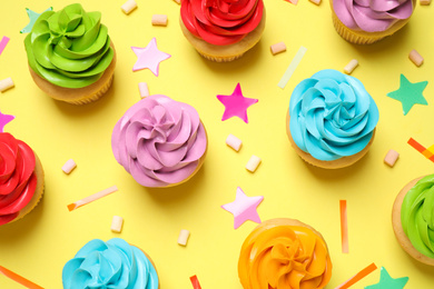 Photo of Colorful birthday cupcakes on yellow background, flat lay