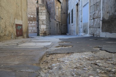 Photo of Empty asphalted alleyway between residential buildings in town