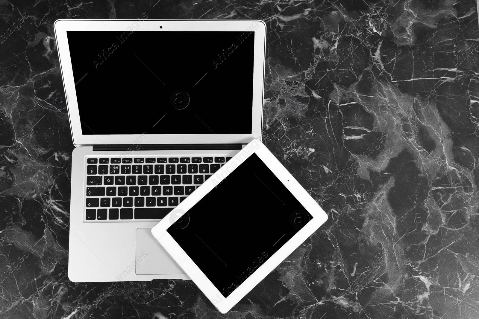 Photo of Devices with blank screens on marble background, top view. Mock up for design