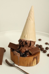 Photo of Delicious ice cream with chocolate in wafer cone served on white table