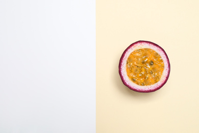 Photo of Half of tasty fresh passion fruit (maracuya) on color background, top view. Space for text