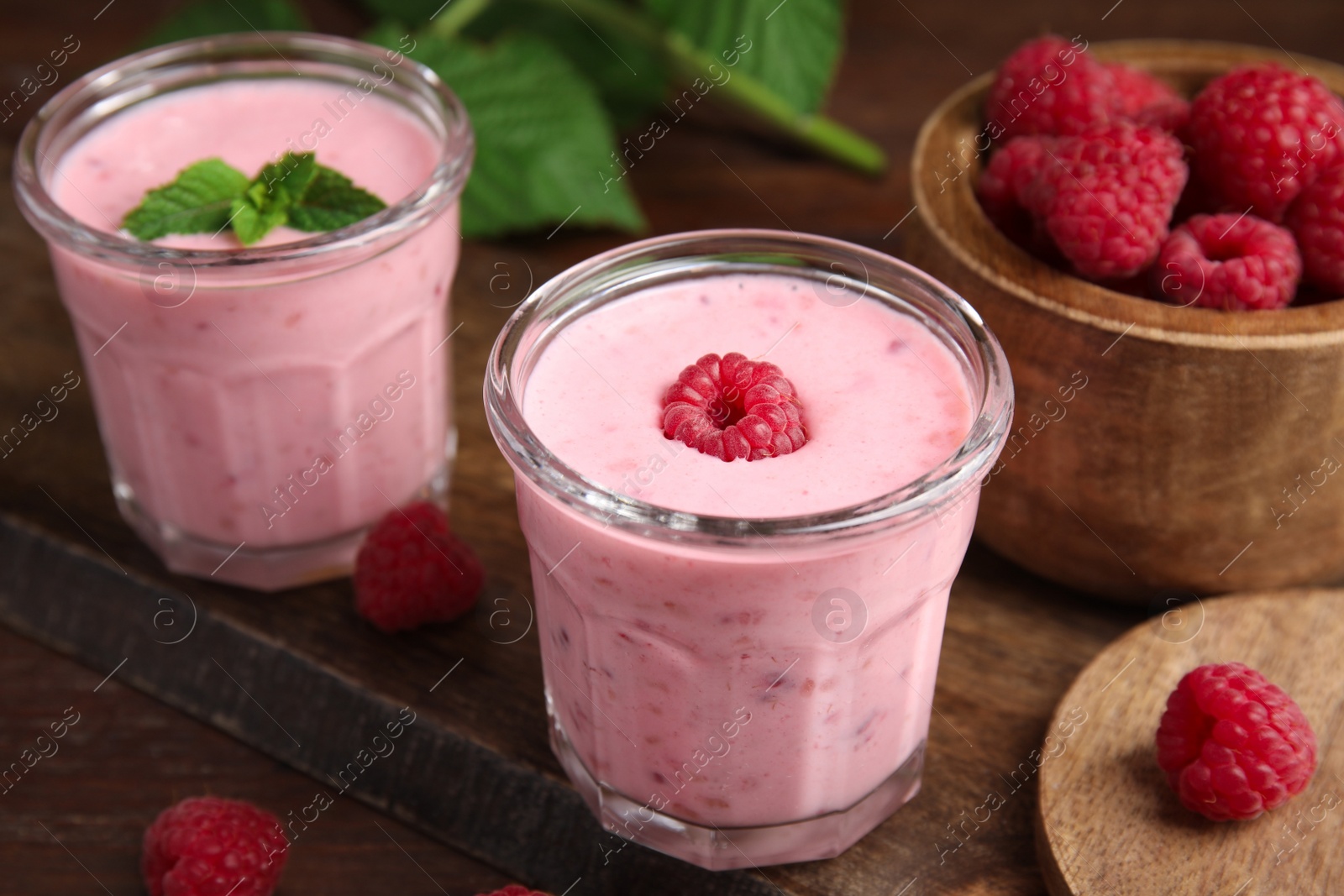 Photo of Tasty fresh raspberry smoothie on wooden table