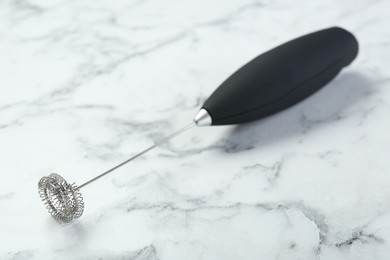 Photo of Black milk frother wand on white marble table