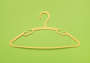 Empty clothes hanger on green background, top view