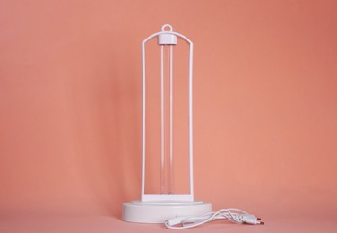 Photo of Ultraviolet lamp on peach background. Air sterilization