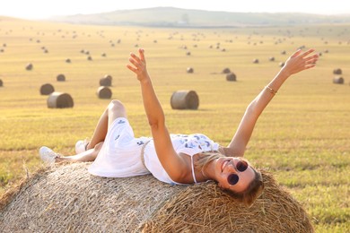 Photo of Beautiful hippie woman on hay bale in field