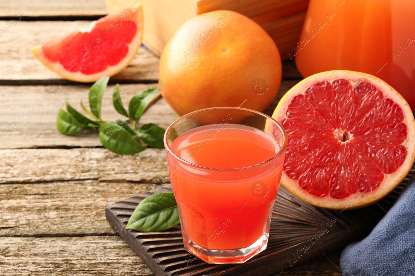 Photo of Glass of delicious grapefruit juice on wooden table