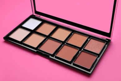 Colorful contouring palette on pink background, closeup. Professional cosmetic product
