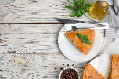 Photo of Delicious meat pie served on white wooden table, flat lay. Space for text