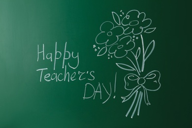 Photo of Green chalkboard with inscription HAPPY TEACHER'S DAY and drawn flowers