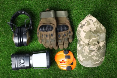 Photo of Different military training equipment on green grass, flat lay