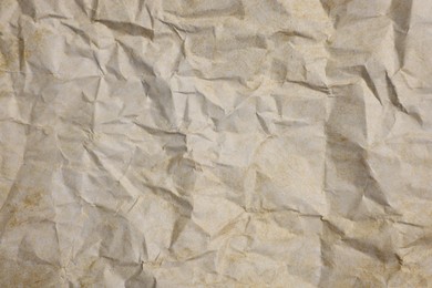 Photo of Texture of crumpled parchment paper as background, top view