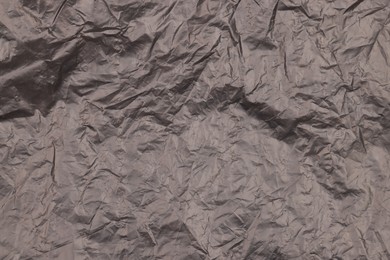 Photo of Crumpled black plastic bag as background, top view