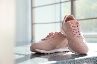 Photo of Pair of stylish women's sneakers on staircase indoors