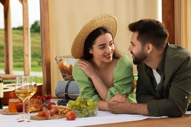 Romantic date. Beautiful couple spending time together during picnic in wooden gazebo