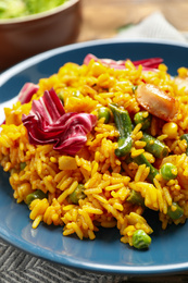 Photo of Delicious rice pilaf with chicken and vegetables on plate, closeup