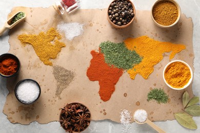 Photo of World map of different spices and products on light grey marble table, top view