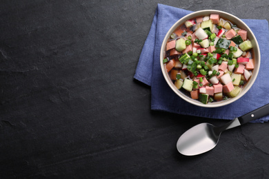 Photo of Delicious cold okroshka with kvass served on black table, flat lay and space for text. Traditional Russian summer soup