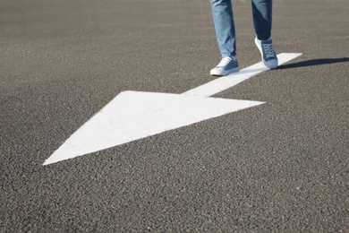 Photo of Woman going along road with arrow marking, closeup
