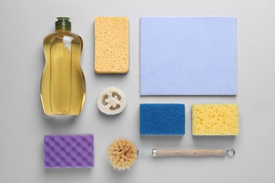 Photo of Flat lay composition with sponges and other cleaning supplies on light grey background