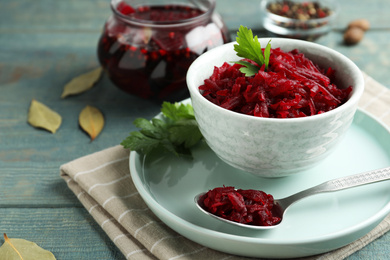 Bowl with delicious pickled beets on blue wooden table