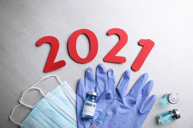 Photo of Flat lay composition with coronavirus vaccine and number 2021 on grey background