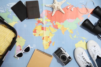 Photo of Flat lay composition with tourist items on world map. Travel agency