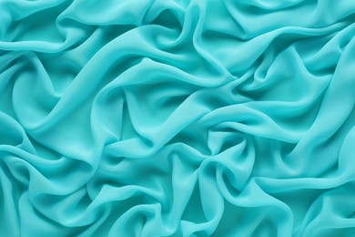 Photo of Beautiful turquoise tulle fabric as background, top view