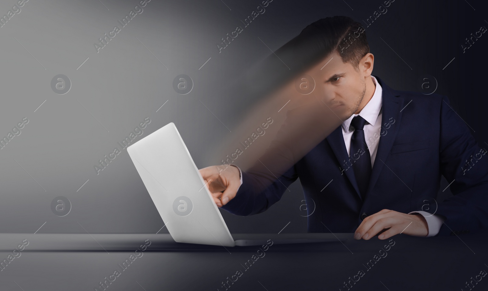 Image of Mind control, brainwashing or work obsession concepts. Man dissolving in laptop at table