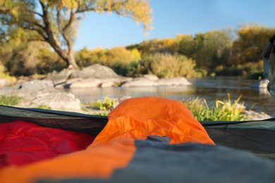 Photo of Camping tent with sleeping bags in wilderness, view from inside