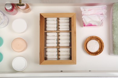 Photo of Storage of tampons and different hygiene products in white drawer, flat lay