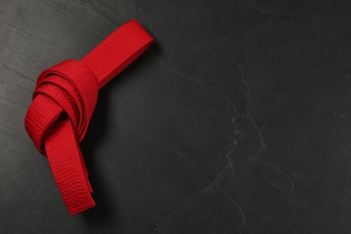 Photo of Red karate belt on gray background, top view. Space for text