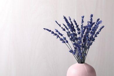 Photo of Bouquet of beautiful preserved lavender flowers near grey wooden wall, space for text