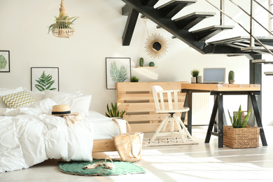 Photo of Elegant interior of bedroom with workplace under stairs