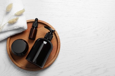 Photo of Different cosmetic products, towel and dry spikes on white wooden table, flat lay. Space for text