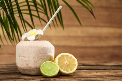 Photo of Open fresh coconut and citrus fruits on wooden table. Space for text