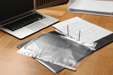 Photo of File folder with punched pockets on wooden table