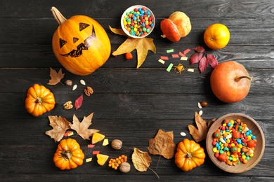 Photo of Halloween pumpkin head jack lantern and holiday decorations on wooden table, flat lay composition with space for text