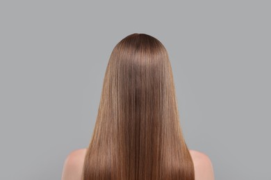Photo of Woman with healthy hair on light grey background, back view