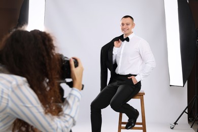 Photo of Handsome model posing for professional photographer in studio