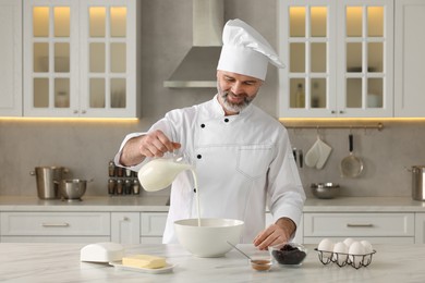 Photo of Professional chef making dough at white marble table in kitchen