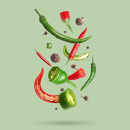 Image of Different spices falling on light green background