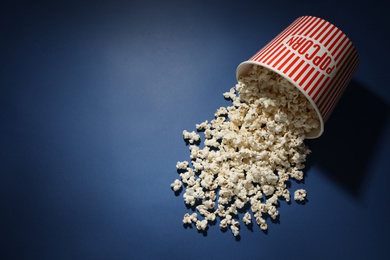 Photo of Delicious popcorn on blue background, top view. Space for text