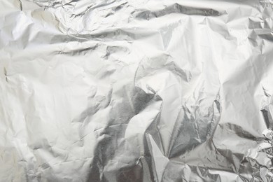 Crumpled silver foil as background, top view