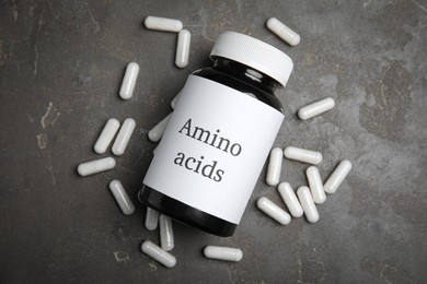 Photo of Amino acid pills on grey table, flat lay