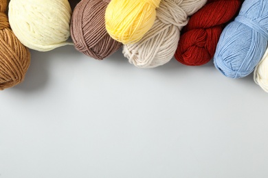 Photo of Soft colorful woolen yarns on white background, flat lay. Space for text