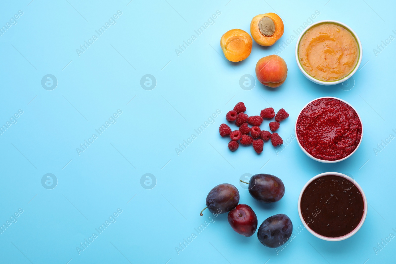 Different puree in bowls and fresh ingredients on light blue background, flat lay. Space for text Photo of Different puree in bowls and fresh ingredients on light blue background, flat lay. Space for text